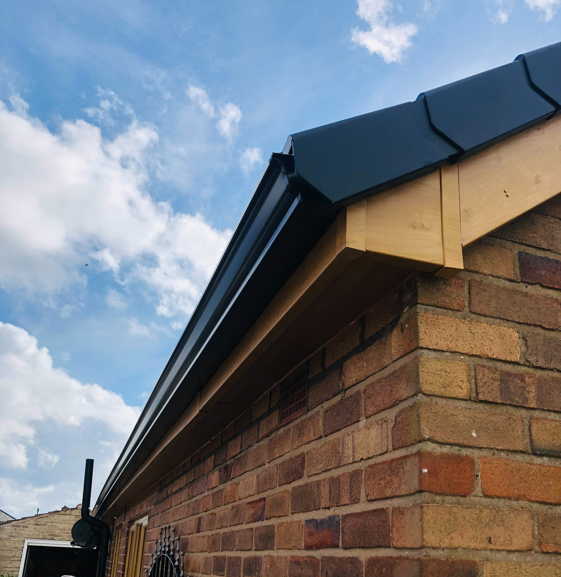 Black fascias and guttering with oak effect soffits