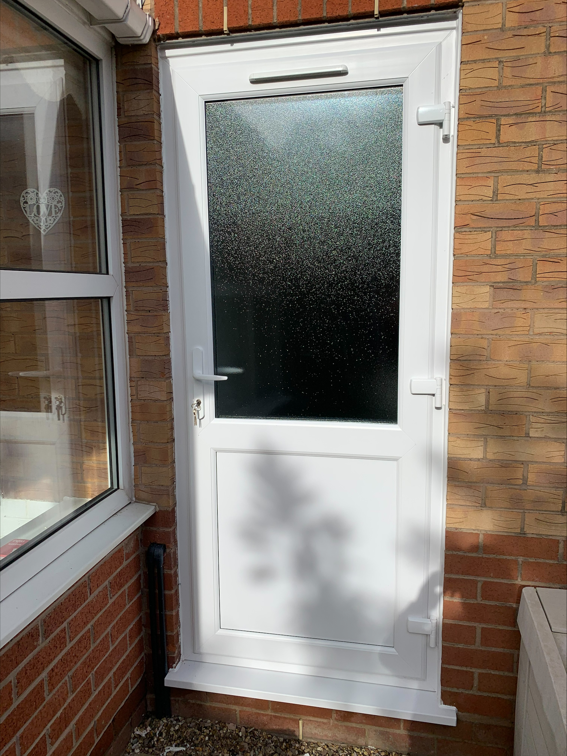 White UPVC back door with frosted glass panel